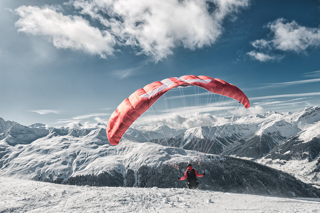 A skier starts for speedriding. Speedriding is a new extreme sport and combines skiing with paragliding.
