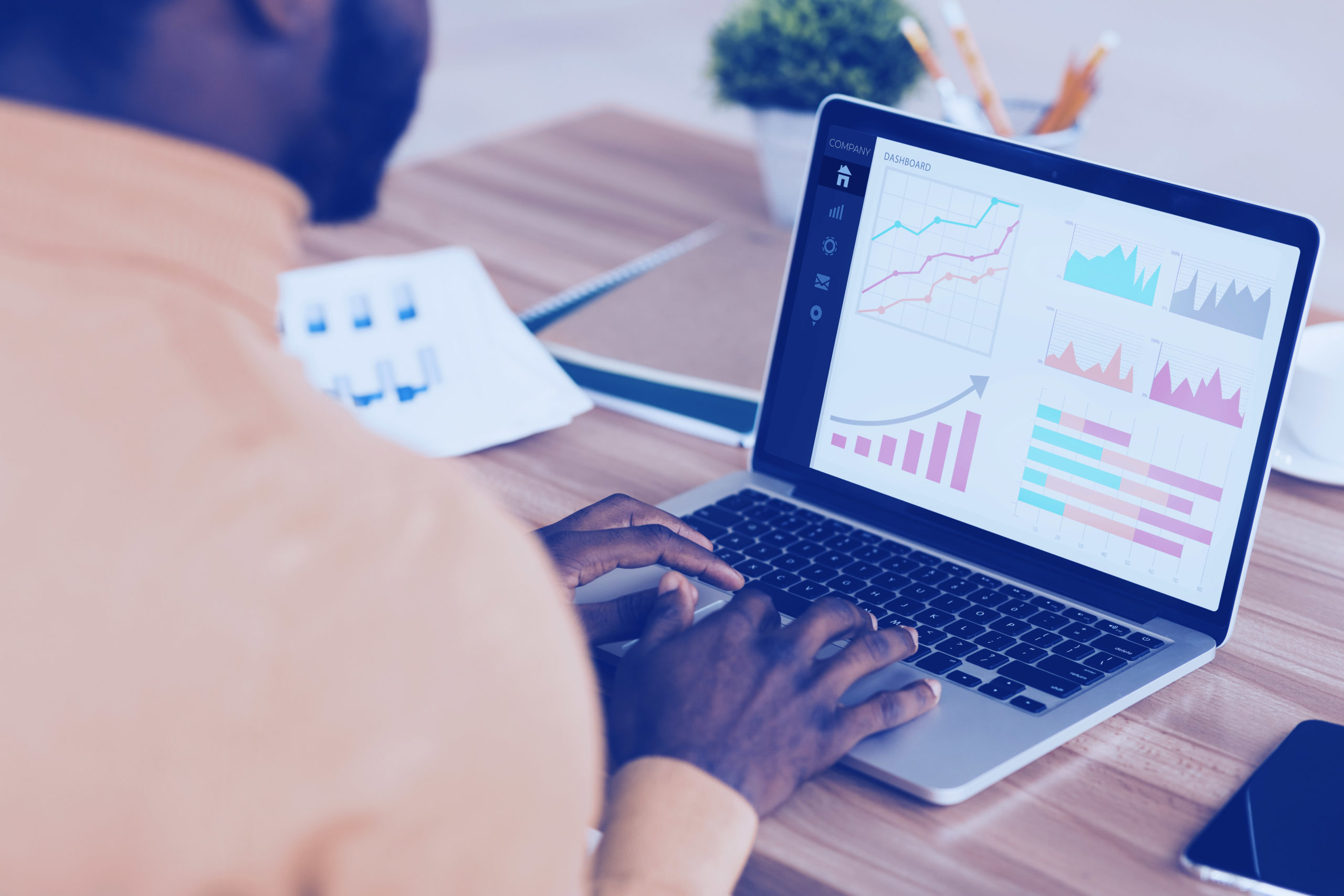 Black entrepreneur analyzing graph on laptop at workplace