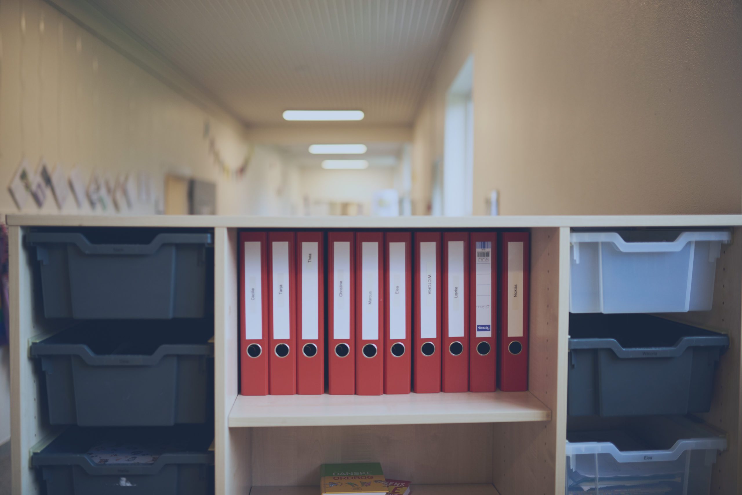 Red binders in a shelf at a school office