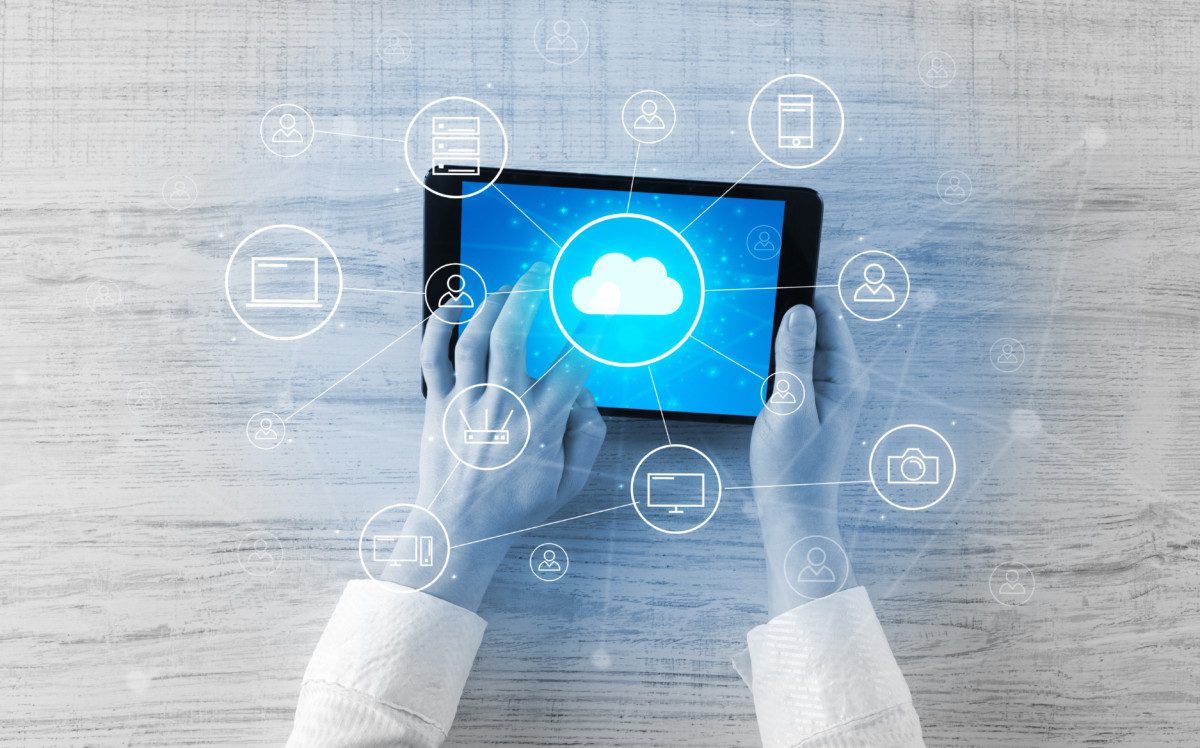 Hand using tablet with centralized cloud computing system concep